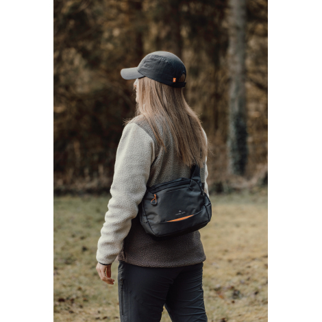 Personne portant le sac en bandoulière de profil en extérieur, sans personnalisation visible