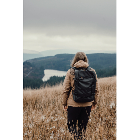 Sac à dos porté par personne debout en extérieur vue de dos, sans marquage visible