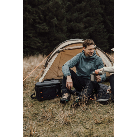 Deux personnes en extérieur avec sac isotherme posé au sol sans personnalisation visible