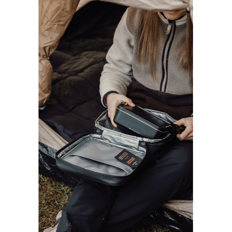 Sac ouvert tenu par une personne montrant les compartiments internes sans marquage visible