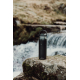 Gourde isotherme noire posée sur un rocher près d’un cours d’eau, sans marquage visible Gourde isotherme noire posée sur un rocher près d’un cours d’eau, sans marquage visible