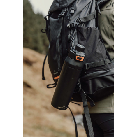 Bouteille fixée sur un sac à dos en extérieur, sans personnalisation visible
