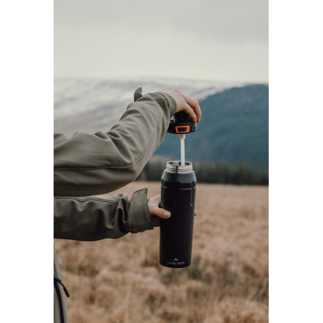Personne ouvrant une bouteille en extérieur, sans personnalisation visible