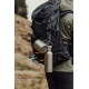 Gourde en titane accrochée à un sac à dos en extérieur, sans personnalisation visible Gourde en titane accrochée à un sac à dos en extérieur, sans personnalisation visible