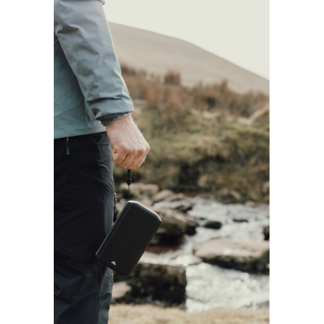 Personne tenant une powerbank solaire à la main en extérieur sans personnalisation visible