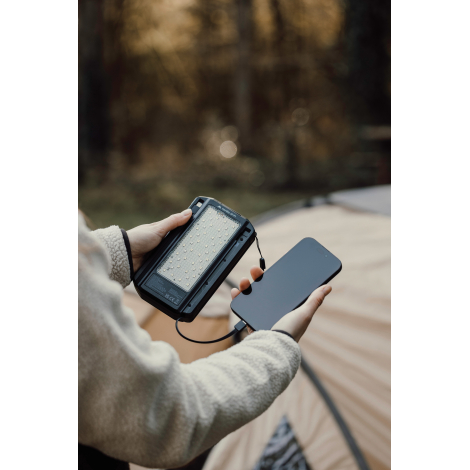 Personne utilisant une powerbank pour charger un téléphone sans marquage visible