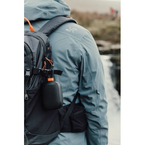 Enceinte accrochée à un sac à dos porté en extérieur sans personnalisation visible