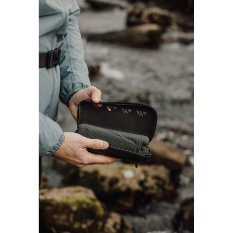 Étui rigide contenant la serviette tenu à la main en extérieur sans marquage visible