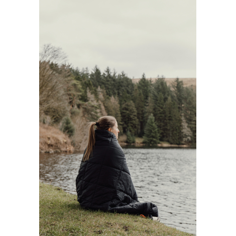 Couverture portée autour des épaules d’une personne en extérieur sans personnalisation visible