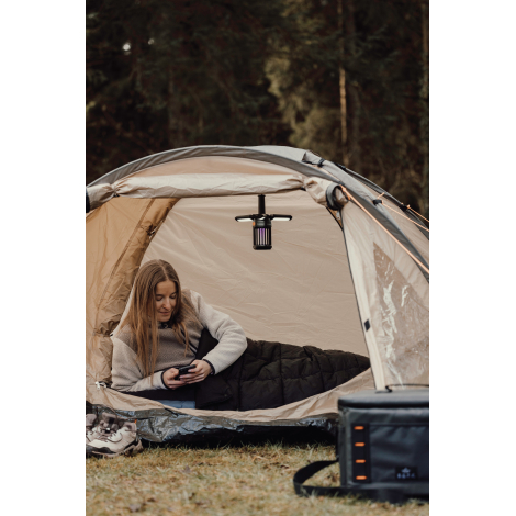 Couverture utilisée dans une tente avec une personne allongée dessous sans marquage visible