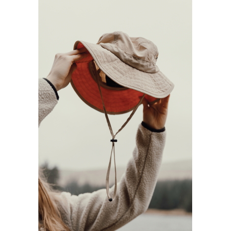 Bob beige tenu en main montrant l’intérieur avec cordon de serrage sans personnalisation visible