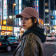 Femme portant la casquette brun délavé dans une rue animée, avec personnalisation visible sur le panneau avant. Femme portant la casquette brun délavé dans une rue animée, avec personnalisation visible sur le panneau avant.