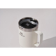 Mug isotherme blanc présenté en situation d’usage, sans personnalisation visible.