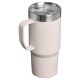 Mug isotherme rose pâle présenté avec poignée et couvercle transparent, sans marquage apparent sur le corps.
