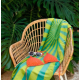 Serviette de plage imprimée disposée sur un fauteuil en rotin avec des accessoires de plage. Serviette de plage imprimée disposée sur un fauteuil en rotin avec des accessoires de plage.