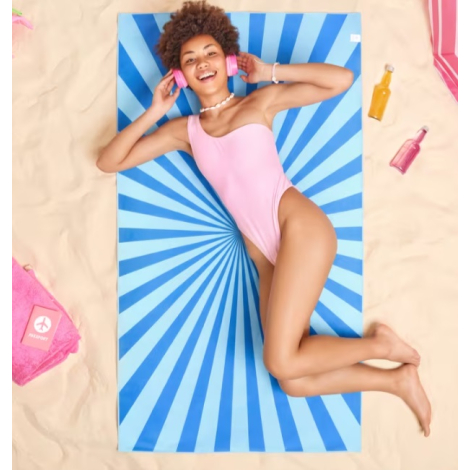 Femme allongée sur une serviette de plage imprimée.