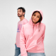 Femme portant un sweat à capuche rose avec un homme en t-shirt rose à l’arrière-plan. Femme portant un sweat à capuche rose avec un homme en t-shirt rose à l’arrière-plan.