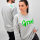Un homme et une femme portent un sweat unisexe gris clair ; un marquage est visible sur la poitrine du modèle femme et un autre Un homme et une femme portent un sweat unisexe gris clair ; un marquage est visible sur la poitrine du modèle femme et un autre