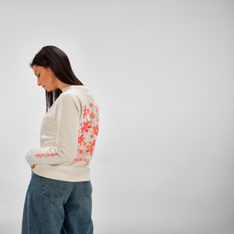 Vue de profil arrière d'une femme portant un sweat femme à col rond écru avec un grand motif personnalisé visible dans le dos et