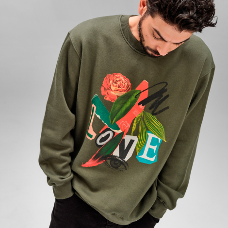 Homme portant un sweat mixte kaki à col rond avec une personnalisation visible sur le devant, couvrant une grande partie de la p