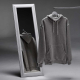 Sweat unisexe gris à capuche suspendu sur un portant devant un miroir, présenté de face avec son reflet au dos, sans personnalis Sweat unisexe gris à capuche suspendu sur un portant devant un miroir, présenté de face avec son reflet au dos, sans personnalis