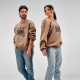 Homme et femme portant des sweats oversize beiges à col rond avec une personnalisation imprimée de grande taille sur le devant. Homme et femme portant des sweats oversize beiges à col rond avec une personnalisation imprimée de grande taille sur le devant.