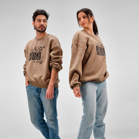 Homme et femme portant des sweats oversize beiges à col rond avec une personnalisation imprimée de grande taille sur le devant.