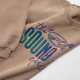 Gros plan d'une personnalisation imprimée multicolore de grande dimension sur le devant d'un sweat oversize beige. Gros plan d'une personnalisation imprimée multicolore de grande dimension sur le devant d'un sweat oversize beige.