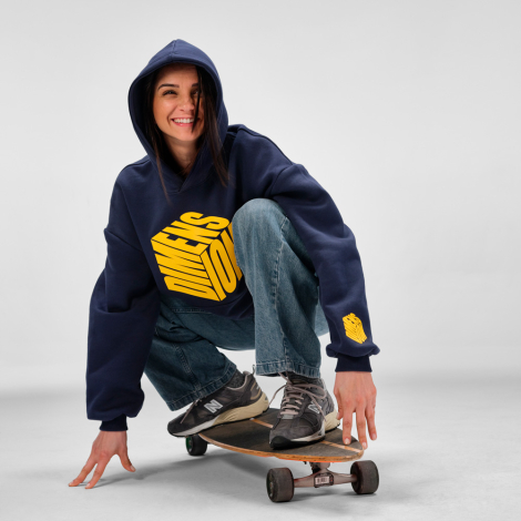 Femme portant un sweat à capuche oversize bleu marine avec une grande personnalisation imprimée sur le devant et un marquage sur