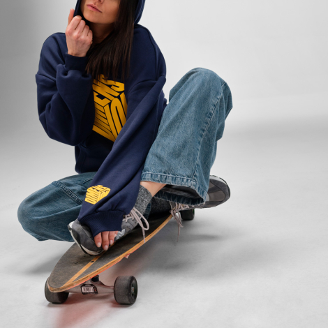Femme portant un sweat à capuche oversize bleu marine avec une grande personnalisation imprimée sur le devant et un marquage sur
