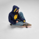 Femme assise sur une planche à roulettes portant un sweat à capuche oversize bleu marine avec une personnalisation imprimée sur Femme assise sur une planche à roulettes portant un sweat à capuche oversize bleu marine avec une personnalisation imprimée sur