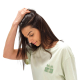 Femme portant un t-shirt vert pastel avec une petite personnalisation en relief sur la poitrine gauche. Femme portant un t-shirt vert pastel avec une petite personnalisation en relief sur la poitrine gauche.