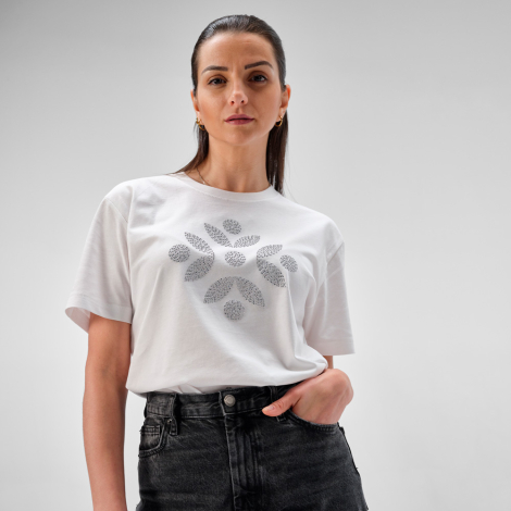 Femme portant un t-shirt blanc avec une personnalisation décorative en strass sur la poitrine.