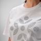 Gros plan d'une personnalisation en strass appliquée sur la poitrine d'un t-shirt blanc. Gros plan d'une personnalisation en strass appliquée sur la poitrine d'un t-shirt blanc.