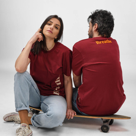 Femme et homme portant des t-shirts bordeaux, avec personnalisation verticale sur le devant du t-shirt femme et personnalisation