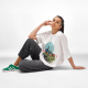 Femme assise portant un t-shirt oversize blanc avec une grande personnalisation graphique imprimée sur le devant. Femme assise portant un t-shirt oversize blanc avec une grande personnalisation graphique imprimée sur le devant.