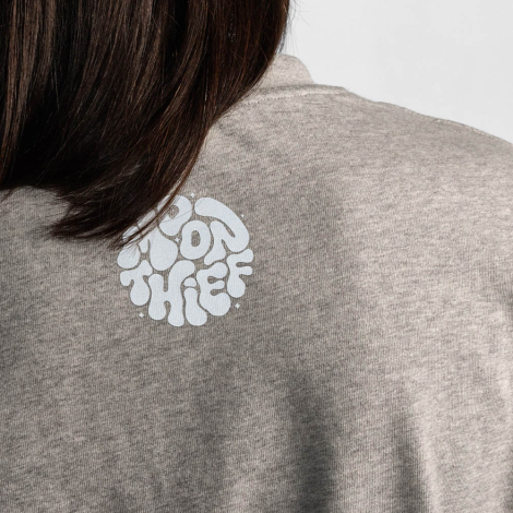 Gros plan du haut du dos d'un t-shirt gris avec une personnalisation imprimée sous le col.